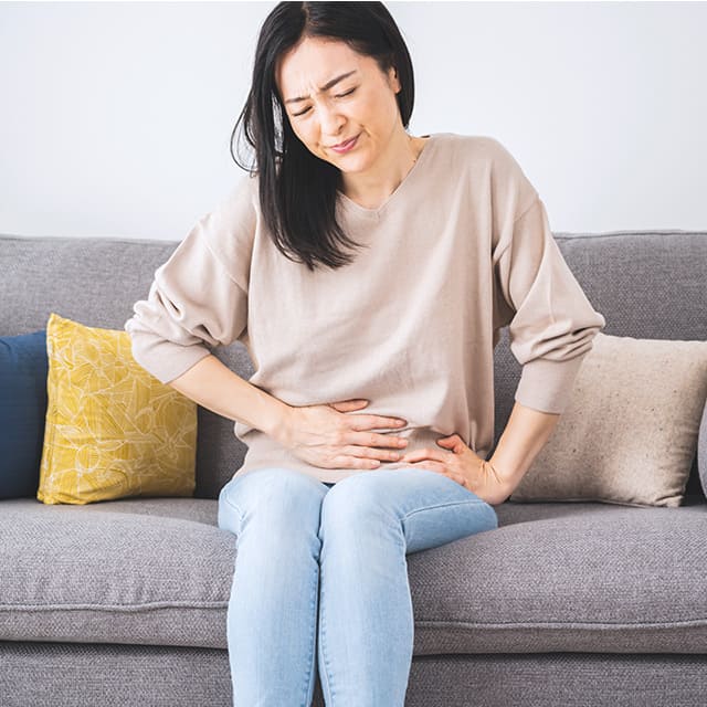 胃を押さえる女性