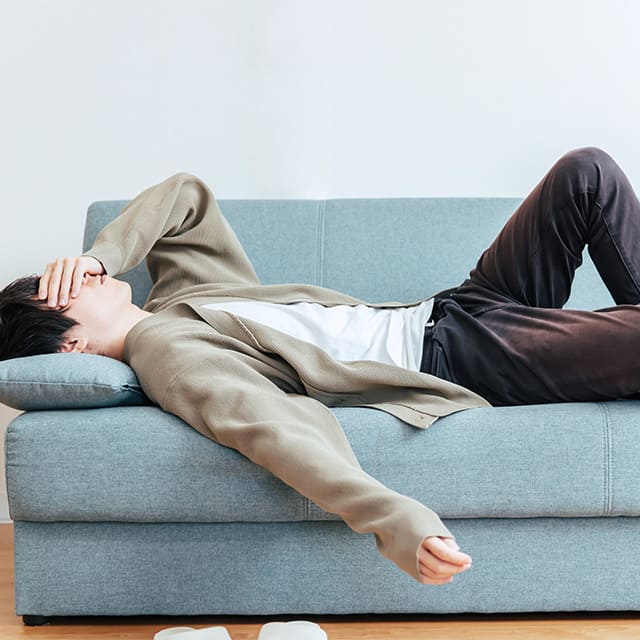 ソファに寝そべる男性